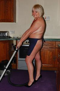 Пожилая домохозяйка делает работу по дому голая